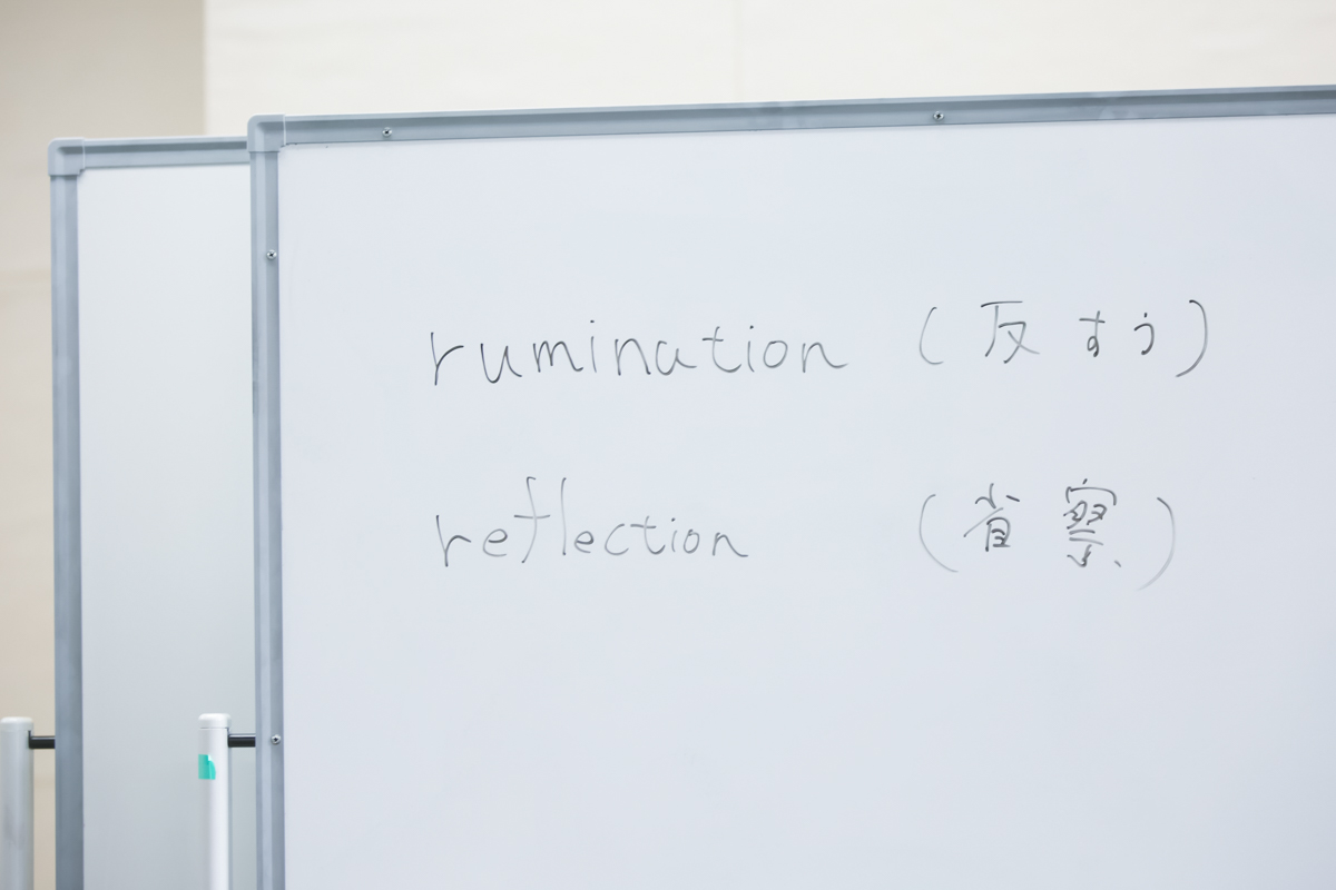 Rumination and Reflection written on a whiteboard in English and Japanese