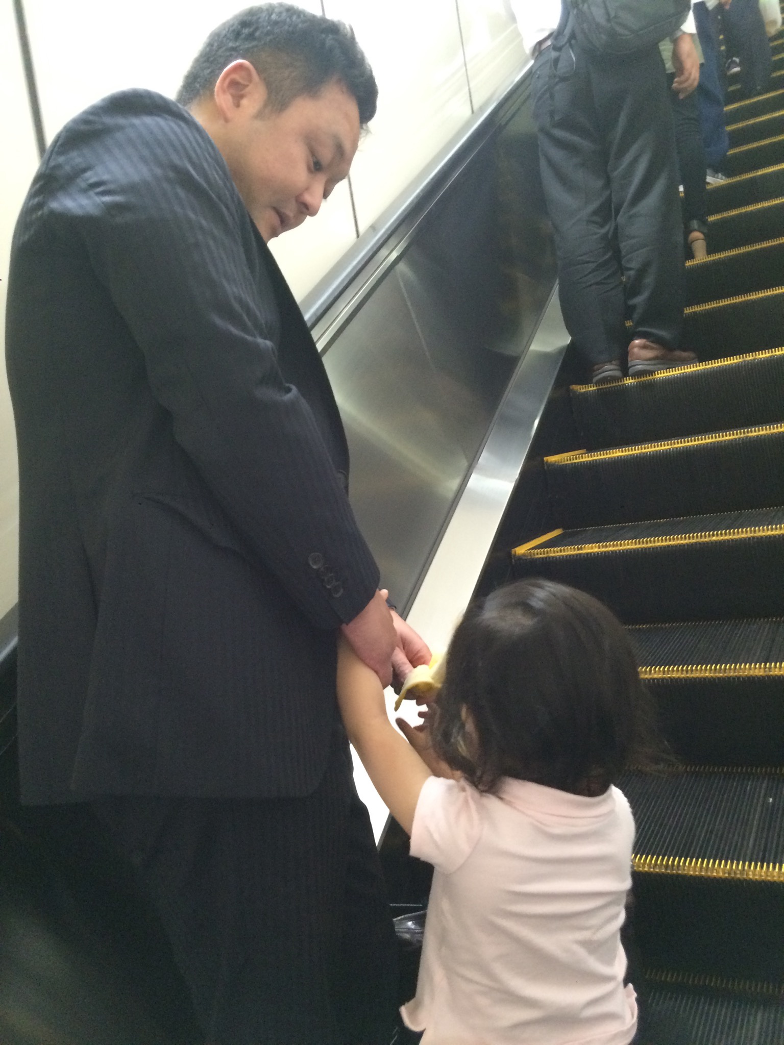 Yosuke rides an escalator with Kenichi's daughter