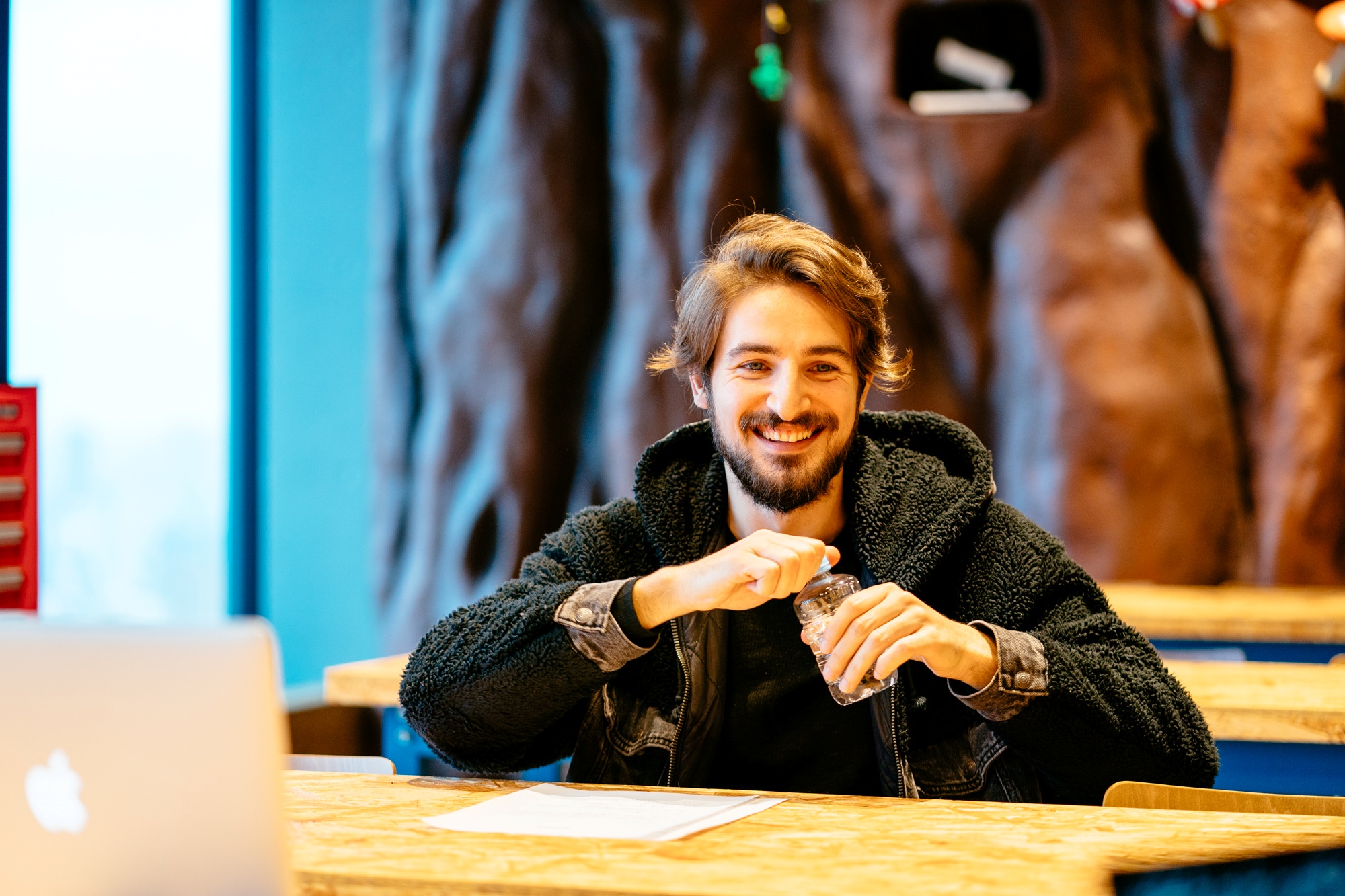 Peppe giving a delighted smile while holding a water bottle